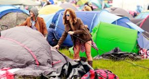 A festival-goer erects her tent on the first day of the Electric Picnic. Photograph: Reuters 