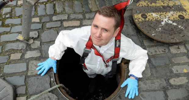 Suited and booted: Karl Whitney at a manhole entrance to the sewers – and the Poddle – on Ship Street in Dublin. Photograph: Frank Miller 