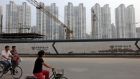 Megopolis: cyclists ride past a construction site in Binhai. Photograph: Doug Kanter/Bloomberg
