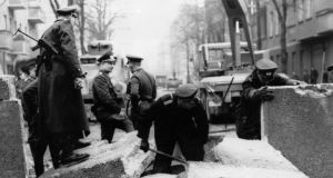 Officers inspecting the damage to the Berlin Wall, East Germany, and making preparations for its repair, after an East German rammed the Wall with an army car and successfully escaped