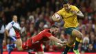  Australia fullback Israel Folau  escapes the challenge of Wales’ Alex Cuthbert to score the first of his two tries in the autumn international at the Millennium Stadium in Cardiff. Photograph:   Michael Steele/Getty Images