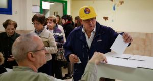 A man bearing a hat with a pro-Catalan independence flag casts his ballot in a symbolic independence vote in Barcelona today. Photograph: Paul Hanna/Reuters 