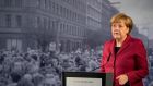 German Chancellor Angela Merkel gives her speech today in front of a photograph depicting the opening of the inner-city border at Bernauer Strasse in 1989. Photograph: Soeren Stache/EPA