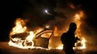 A police car burns on the street after a grand jury returned no indictment for police officer Darren Wilson in the August shooting of Michael Brown, in Ferguson, Missouri, late last night.   Photograph: Jim Young/Reuters
