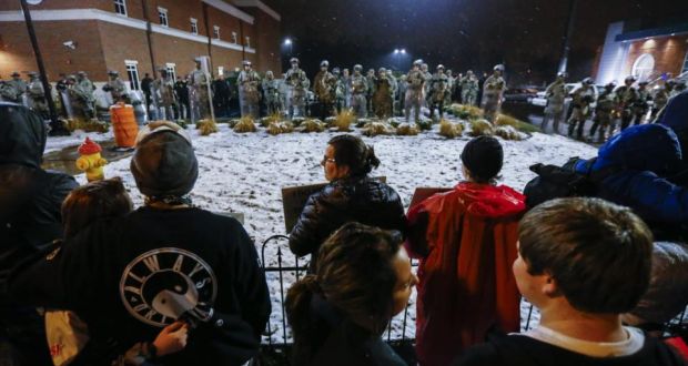 Protestors chanted as members of the Missouri National Guard defended police headquarters in Ferguson, Missouri, on Wednesday night. Hundreds of protesters returned to the streets  to demonstrate over  a controversial verdict in the case of Michael Brown (18) being shot by police officer Darren Wilson. Photograph: Tannen Maury/EPA.