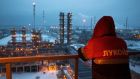 An employee looks out over an oil refinery  in Nizhny Novgorod, Russia. The drop in oil prices is driving a sharp recession in the country. Photograph: Andrey Rudakov/Bloomberg