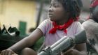 A girl holds a gun in a truck just prior to a rebel attack in July 2003 outside Monrovia in Liberia. The UN believes arms dealers used HSBC accounts. Photograph: Chris Hondros/Getty