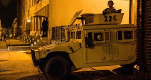 Members of the National Guard sit parked in a humvee in the Sandtown neighborhood where Freddie Gray was arrested. Photograph:  Andrew Burton/Getty Images