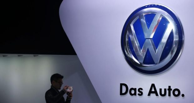  A man taking photos beside the Volkswagen logo at the 16th Shanghai International Automobile Industry Exhibition in Shanghai, China, in April. A  vast shopping spree  in past years built up the now titanic Volkswagen Group. Photograph: How Hwee Young/EPA