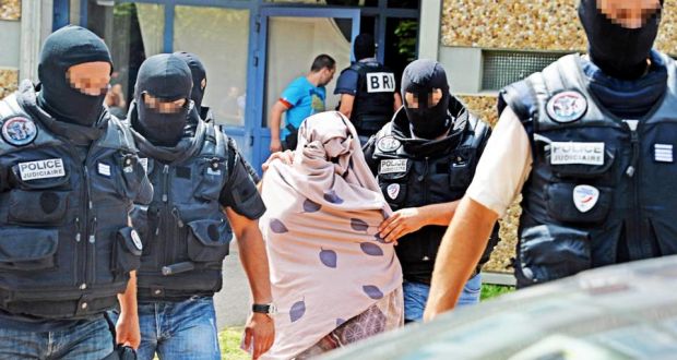 Police lead away an unidentified woman as they search Yassin Salhi’s home in Saint-Priest, near Lyon. Photograph: Richard Mouillaud/EPA