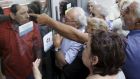 Pensioners waiting outside a closed National Bank branch and hoping to get their pensions, argue with a bank employee in Iraklio on the island of Crete. Photograph:  Reuters/Stefanos Rapanis 