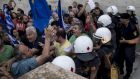 Pro-euro protesters tussle with riot police at a rally in front of the Greek parliament building in  Athens on Tuesday night. Photograph: Marko Djurica/Reuters