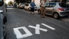 Pedestrians walk along a road displaying an “OXI” or “No” campaign sign against bailout proposals in Athens, Greece, on Friday. Greece is divided  heading into Sunday’s referendum on European bailout proposals. Photograph: Yorgos Karahalis/Bloomberg