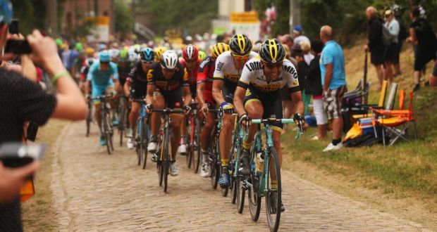 The peloton hits the cobbles on stage four of the Tour, a 223km stage between Seraing and Cambrai. Photograph: Bryn Lennon/Getty Images
