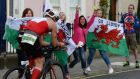 Supporters with Welsh flags cheer on a rider in Dún Laoghaire during the IronMan triathlon  in Dublin on Sunday. Photograph: Cyril Byrne/The Irish Times