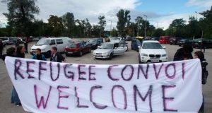 Activists hold a banner at a parking lot in Vienna before a convoy of around 140 cars leaves for Hungary to distribute aid and collect refugees to bring back to Austria. Photograph: Heinz-Peter Bader/Reuters