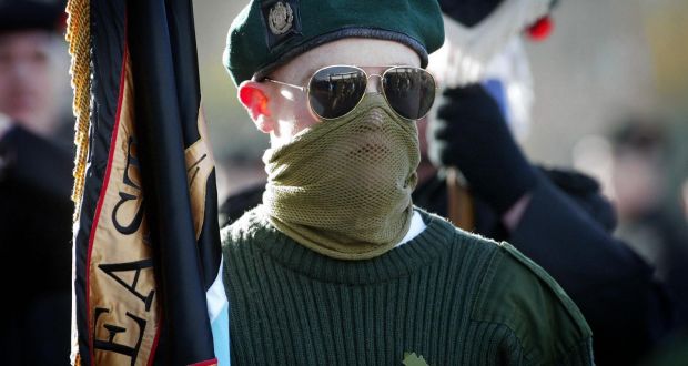 A masked member of the Ulster Defence Association (UDA) colour party at a Remembrance Day service  in  north Belfast, in  2004. Photograph: PA 