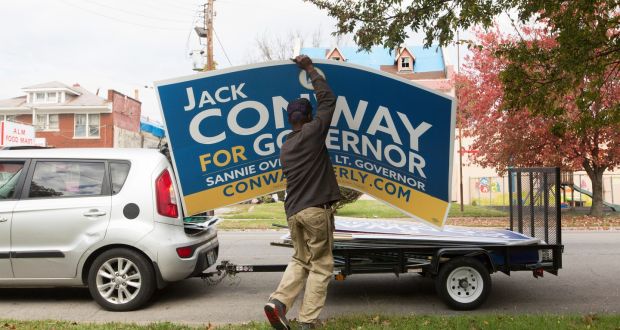 A Democratic Party supporter in Louisville takes down a sign supporting Jack Conway, the defeated candidate in the Kentucky governorship election. Photograph: Philip Scott Andrew/The New York Times