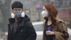 A couple wear masks  in a shopping district of Beijing amid heavy smog after the city issued its first ever red alert for air pollution. Photograph: Kim Kyung-Hoon/Reuters