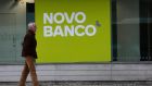 A man walks past an office of the Portuguese bank Novo Bank (New Bank) in Lisbon.
