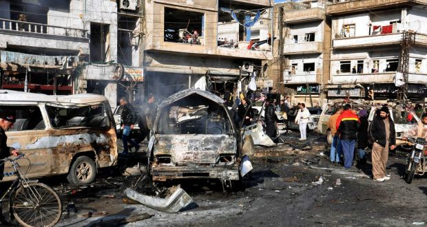  Syrian policemen and citizens at  the site of two terrorist bomb attacks at a security checkpoint in the residential neighborhood of Zahra, Homs. Photograph: SANA/EPA