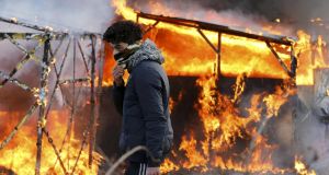 Razed hell: a shelter burns in the “Jungle” migrant camp outside Calais. Photograph: Pascal Rossignol/Reuters