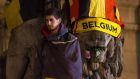 Bear witness: A man cloaked in a Belgian flag looks on as hundreds of people at a makeshift memorial gather before Brussels Stock Exchange on Place de la Bourse. Photograph: Getty Images 
