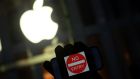 An anti-government protester holds his iPhone with a sign ‘No Entry’ during a demonstration near the Apple store on Fifth Avenue in New York. Photograph: Jewel Samad/AFP/Getty Images 