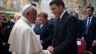 Pope Francis shakes hands with Italian premier Matteo Renzi, as German chancellor Angela Merkel looks on, during a ceremony where he was awarded the International Charlemagne Prize of Aachen (Karlspreis) at the Vatican on Friday. Photograph:  L’Osservatore Romano/Pool Photo via AP