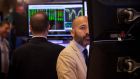 Traders work on the floor of the New York Stock Exchange. US stocks were higher in trading on Friday, with the S&P and Dow on track to eke out their first weekly gains in five weeks as technology and financial stocks rose.