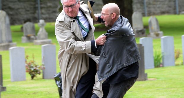 A protester is removed from the State ceremonial event marking the deaths of British Soldiers in the Easter Rising, at Grangegorman military cemetery in Dublin. Photograph: Eric Luke/The Irish Times