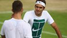 Roger Federer of Switzerland talks to Jiri Vesely of the Czech Republic during a practice session prior to the Wimbledon Lawn Tennis Championships at the All England Lawn Tennis and Croquet Club. Photo: Getty Images