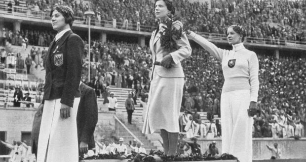 Helene Mayer of Germany raises her right arm in a Nazi salute after winning silver at the 1936 Berlin Olympics alongside Ellen Preis of Austria (bronze) and Hungary&rsquo;s Ilona Elek-Schakerer (gold). Photo: Getty Images