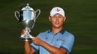 Si Woo Kim of South Korea poses with the trophy after winning the final round of the Wyndham Championship at Sedgefield Country Club. Photograph: Kevin C. Cox/Getty Images