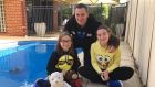 Mark Cunningham poolside with his daughters Olivia and Kerri in Perth.