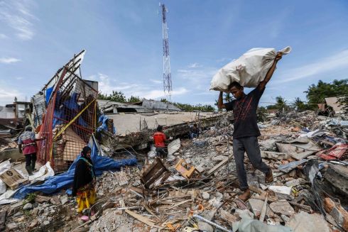 INDONESIA: Indonesian villagers collect belongings from a collapsed building after a 6.5 magnitude earthquake struck Pidie Jaya, Aceh, Indonesia. Photograph: Hotli/Simanjuntak/EPA