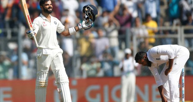 Indian cricket captain Virat Kohli, left, celebrates a double century on the fourth day of the fourth Test in Mumbai, India. Photograph:  Rafiq Maqbool/AP 