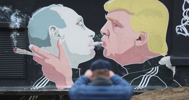 A  man photographs a mural showing Donald Trump blowing marijuana smoke into the mouth of Vladimir Putin in Vilnius, Lithuania. Photograph: Sean Gallup/Getty