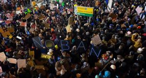 Protesters  at John F. Kennedy International Airport in New York on  Saturday evening after  two Iraqi refugees were detained while trying to enter the country. Photograph: AP 