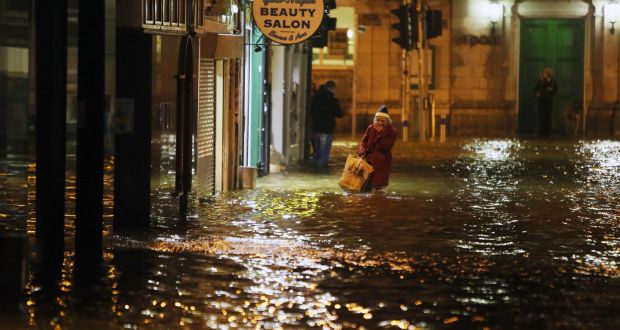 A woman walks through flood water in Cork city. File photograph: Niall Carson/PA Wire