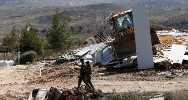 A bulldozer demolishes a home in the recently evicted illegal Israeli settler outpost of Amona. Israel has passed a law retroactively legalising about 4,000 settler homes built on privately owned Palestinian land in the occupied West Bank. Photograph: Baz Ratner/Reuters