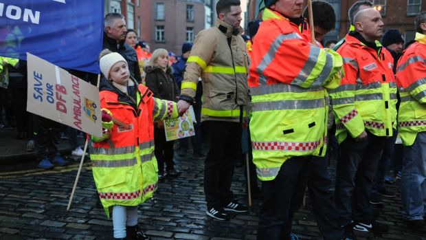 Cassie Crosbie holds her father Terry Crosbie’s hand at a Dublin Fire Brigade protest outside Dublin City Hall. Photograph: Aidan Crawley