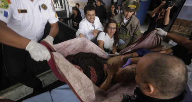 Volunteer firefighters rescue a girl from a fire at a children’s shelter in Guatemala City. Photograph: Danilo Ramirez/AFP/Getty Images
