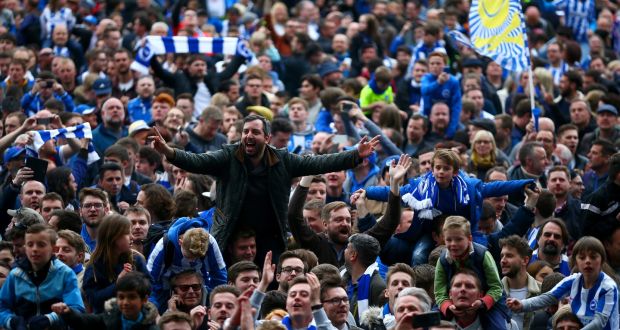 Brighton & Hove Albion fans celebrate on the pitch after their team’s victory against Wigan Athletic at Amex Stadium. Photograph: Dan Istitene/Getty Images