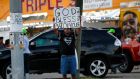 Everett Matthews, of Baton Rouge, holds up a sign outside the Triple S Food Mart on Tuesday night. Photograph: Gerald Herbert/AP