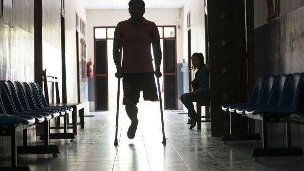 A man arrives at the Cope centre in Vientiane, Laos. Cope was formed in 1997 in response to the need to provide UXO (unexploded ordnance) survivors with care and support, and orthotic and prosthetic devices which are made on site at the centre. Photograph: Brenda Fitzsimons
