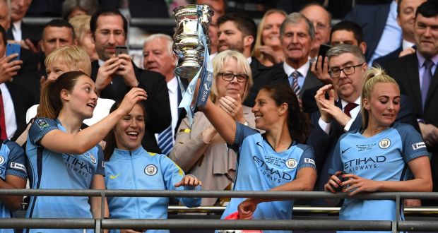  Megan Campbell (left) looks on as her Manchester City team-mate  Carli Lloyd  celebrates with the Women’s FA Cup final trophy after the win over Birmingham City at Wembley. Photograph:  Ross Kinnaird/Getty Images