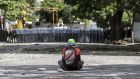 A demonstrator sits in front of a line of Bolivarian National Guard officers in Caracas, Venezuela. Photograph: Nathalie Sayago/EPA