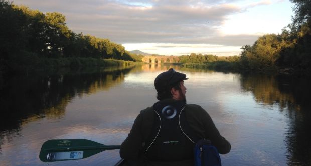 Dan paddles down the Barrow river in an open-top Canadian canoe