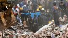 Firefighters and rescue workers remove the body of a victim from debris at the site of a collapsed building in Mumbai, India, on Thursday. Photograph: Shailesh Andrade/Reuters